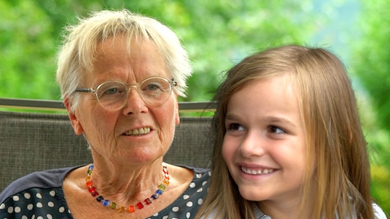 Eine ältere Dame und ein junges Mädchen lächeln in die Kamera